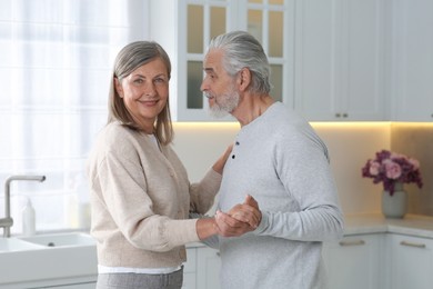 Photo of Senior couple spending time together in kitchen