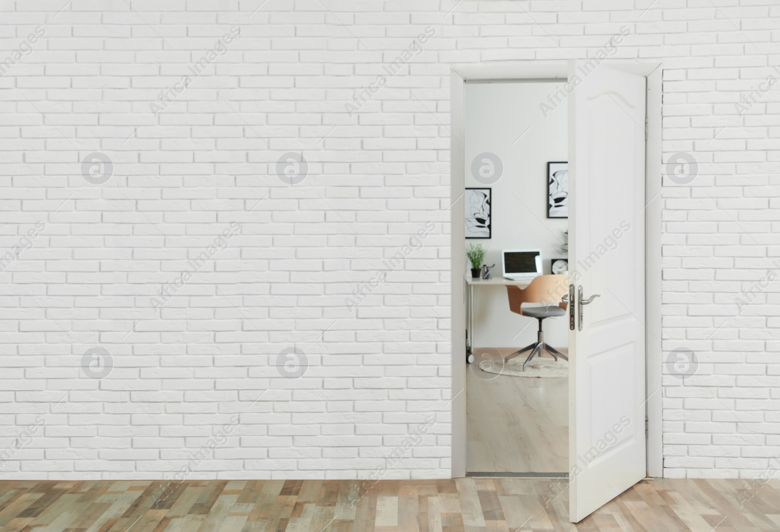 Photo of Stylish home office interior, view through open door. Space for text