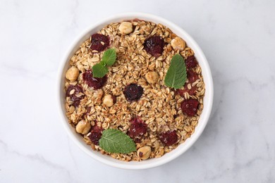 Photo of Tasty baked oatmeal with berries and nuts on white marble table, top view