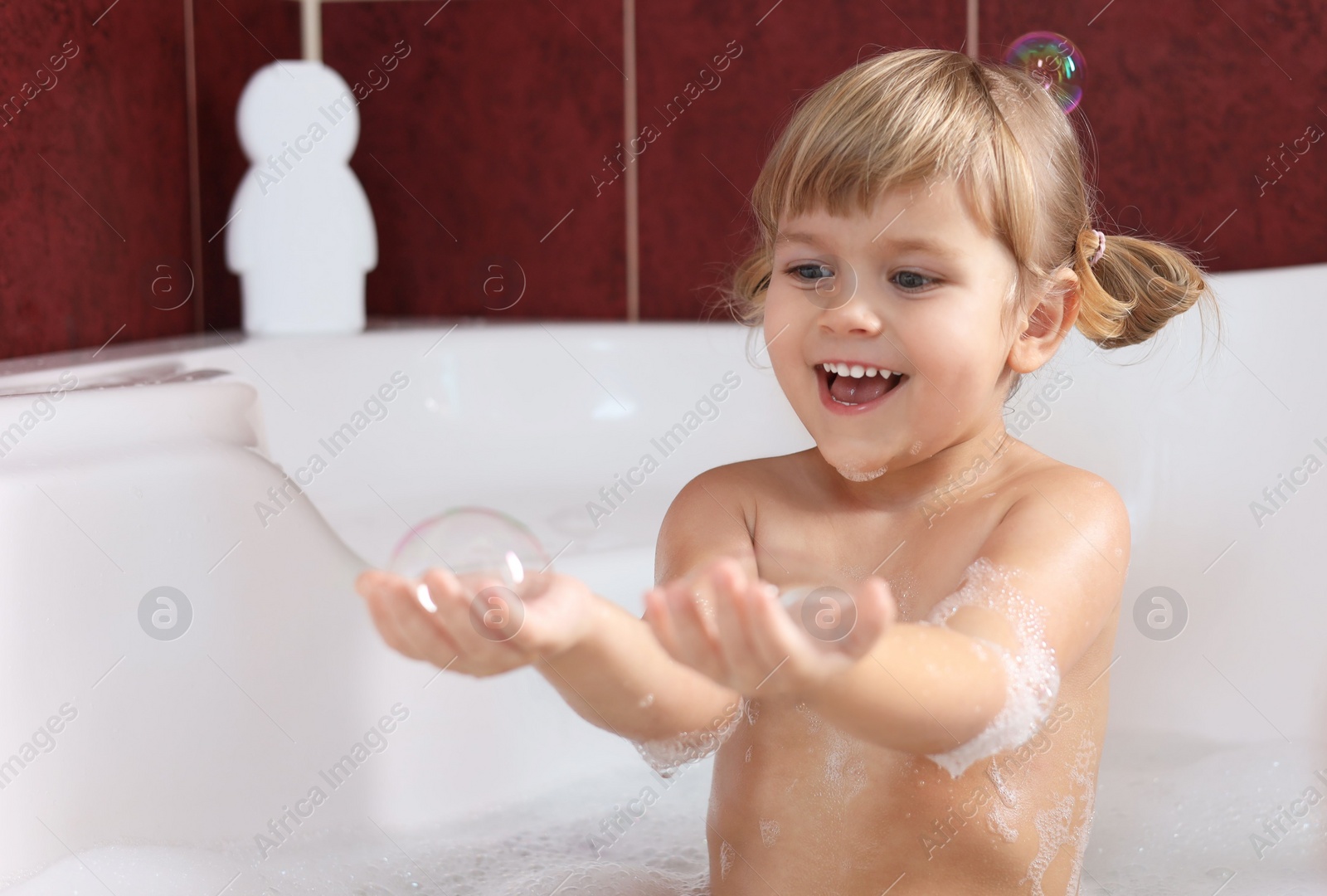 Photo of Happy girl having fun in bathtub at home