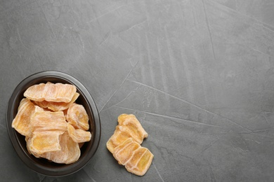 Delicious dried jackfruit slices on grey table, flat lay. Space for text