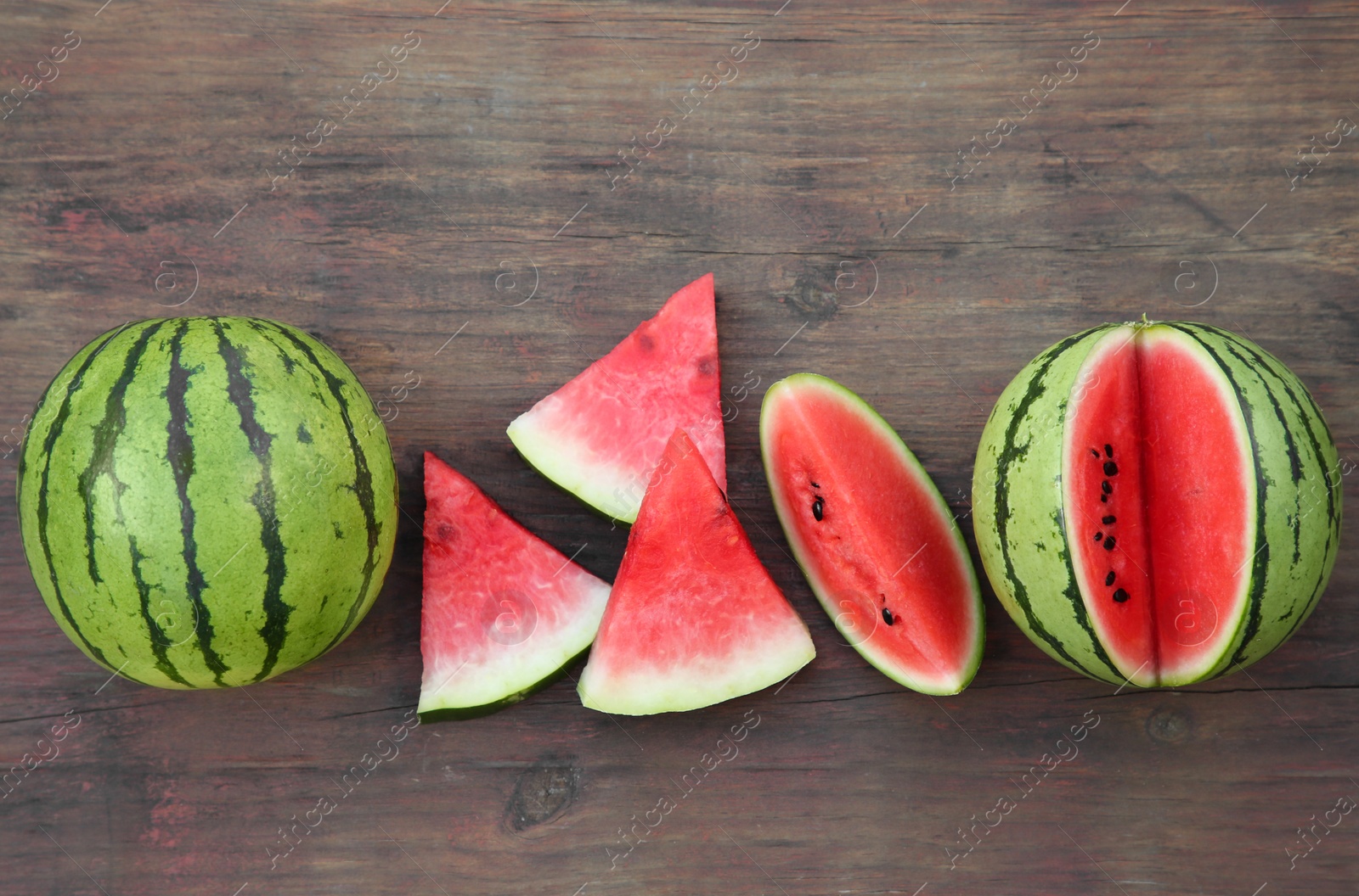 Photo of Delicious ripe watermelons on wooden table, flat lay