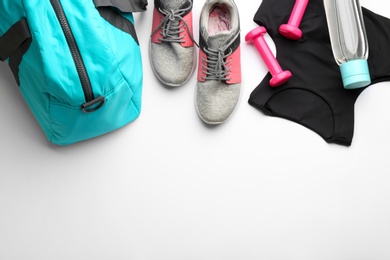 Flat lay composition with gym bag and sportswear on white background