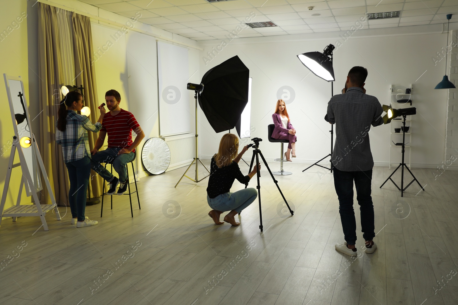 Photo of Photo studio with professional equipment and team of workers