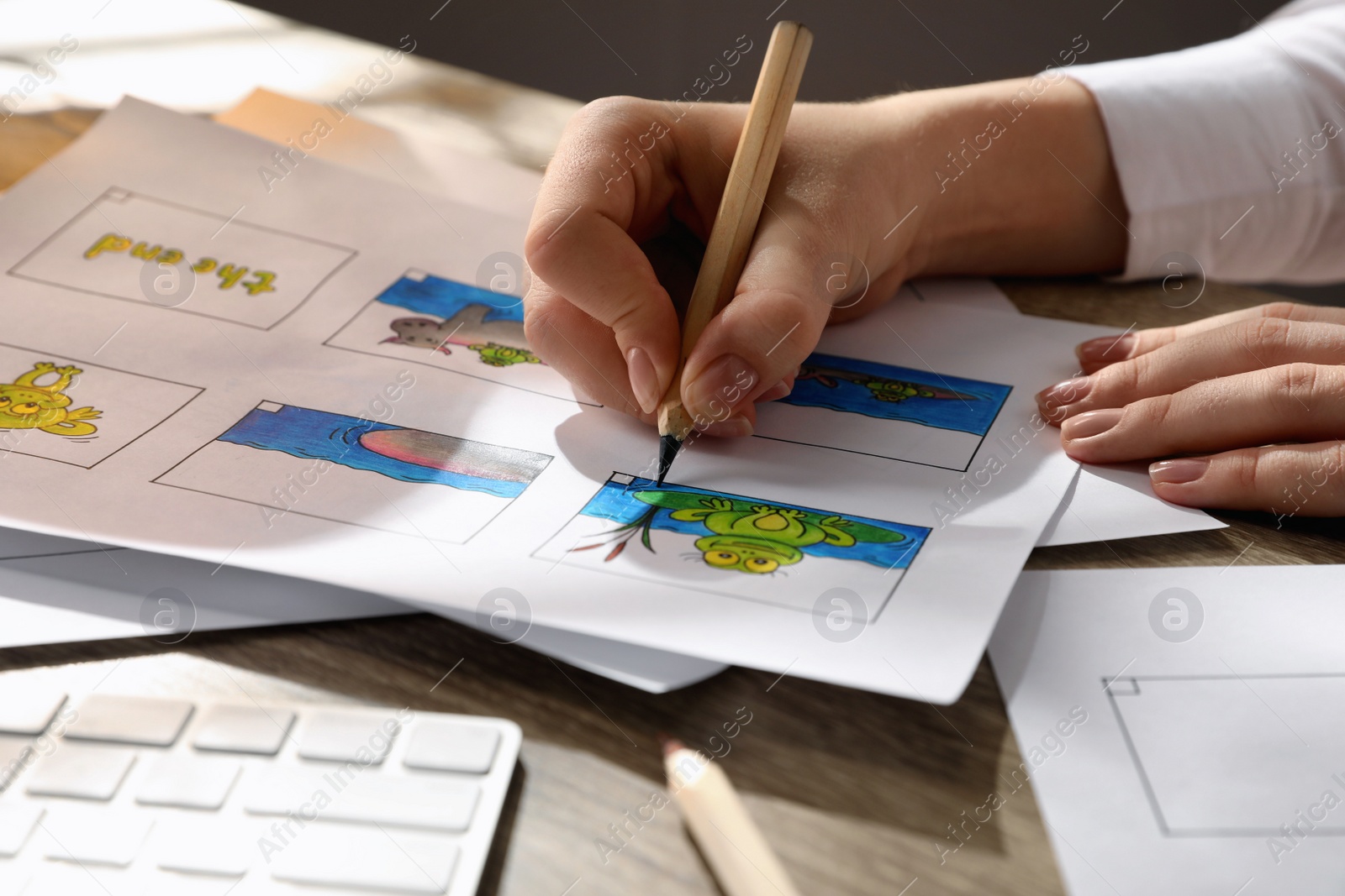 Photo of Woman drawing cartoon sketch in storyboard at workplace, closeup. Pre-production process