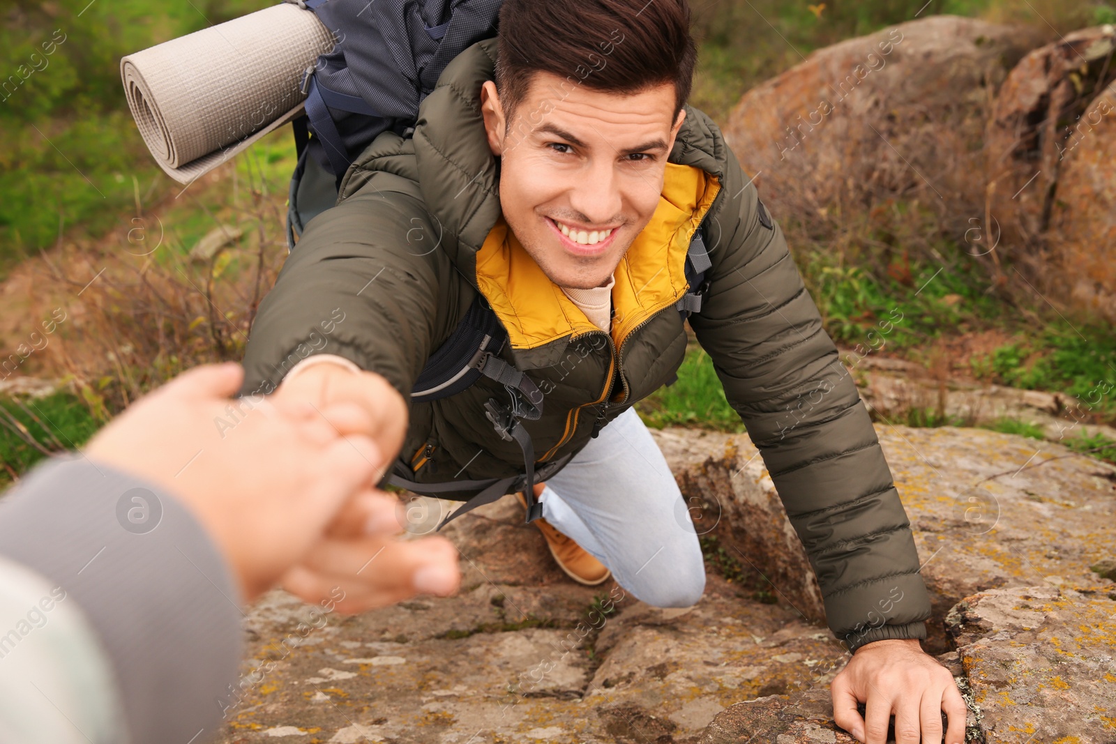 Photo of Couple of hikers with backpacks climbing up mountains