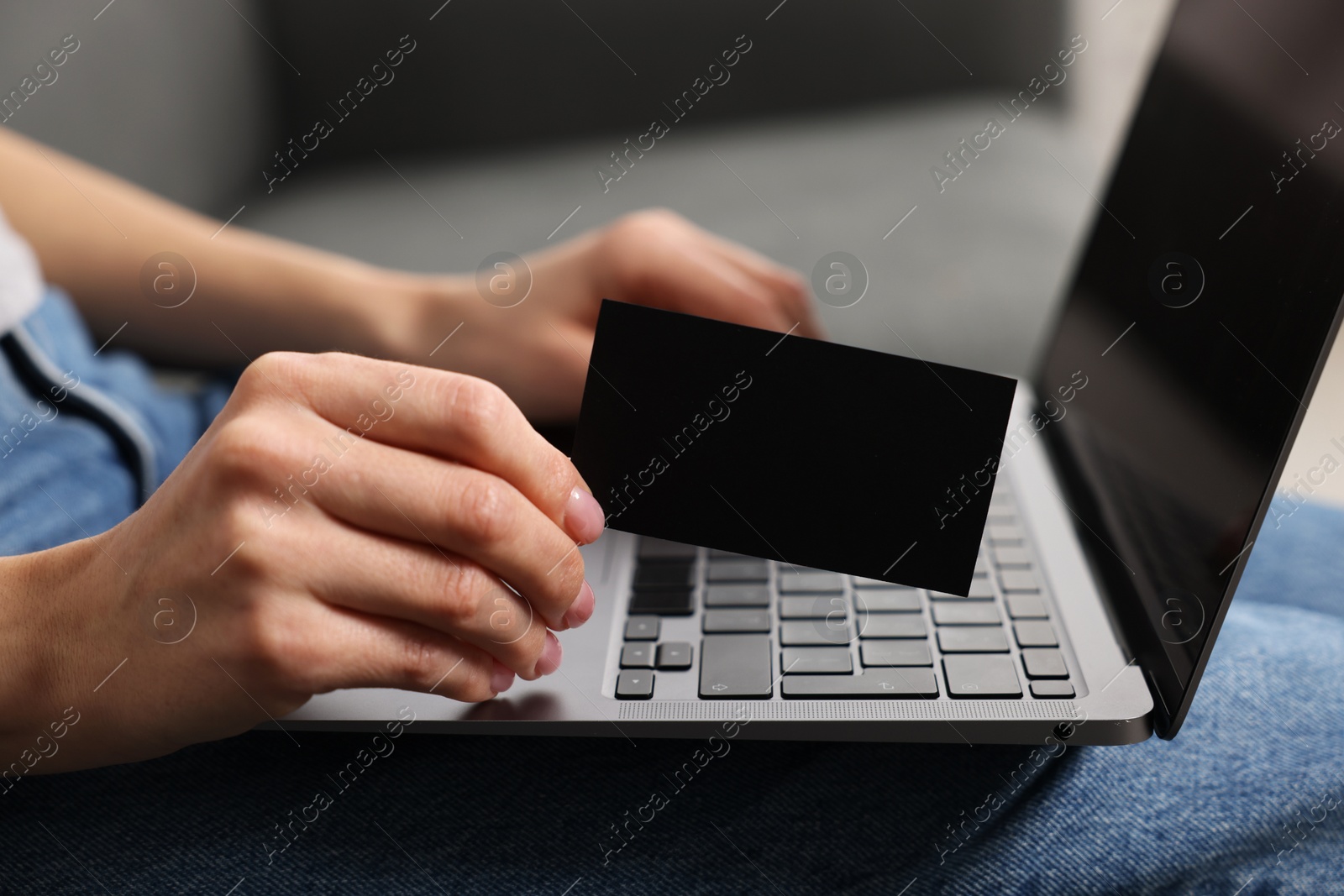Photo of Woman with laptop holding blank business card, closeup. Space for text