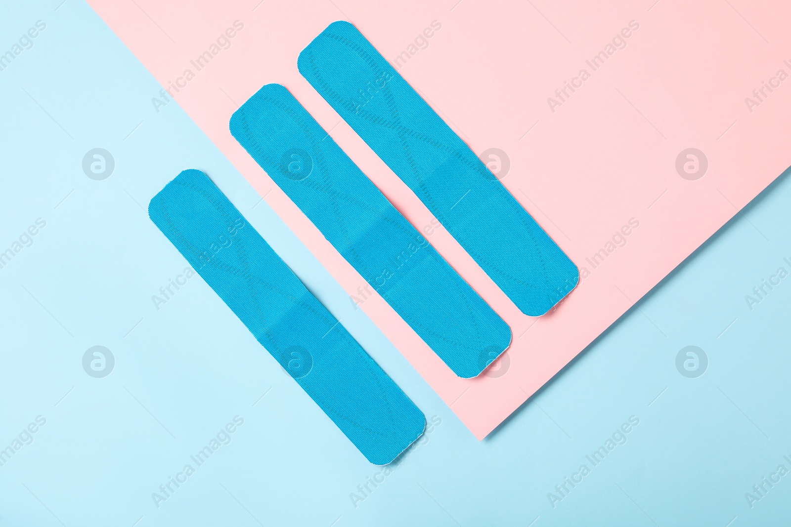 Photo of Bright kinesio tape pieces on color background, flat lay