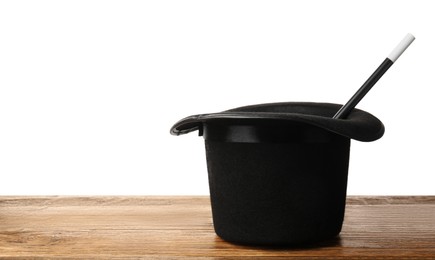 Photo of Magician's hat and wand on wooden table against white background