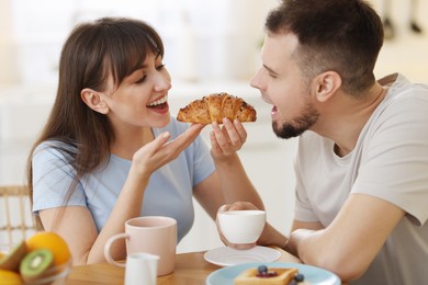 Photo of Happy couple having tasty breakfast at home