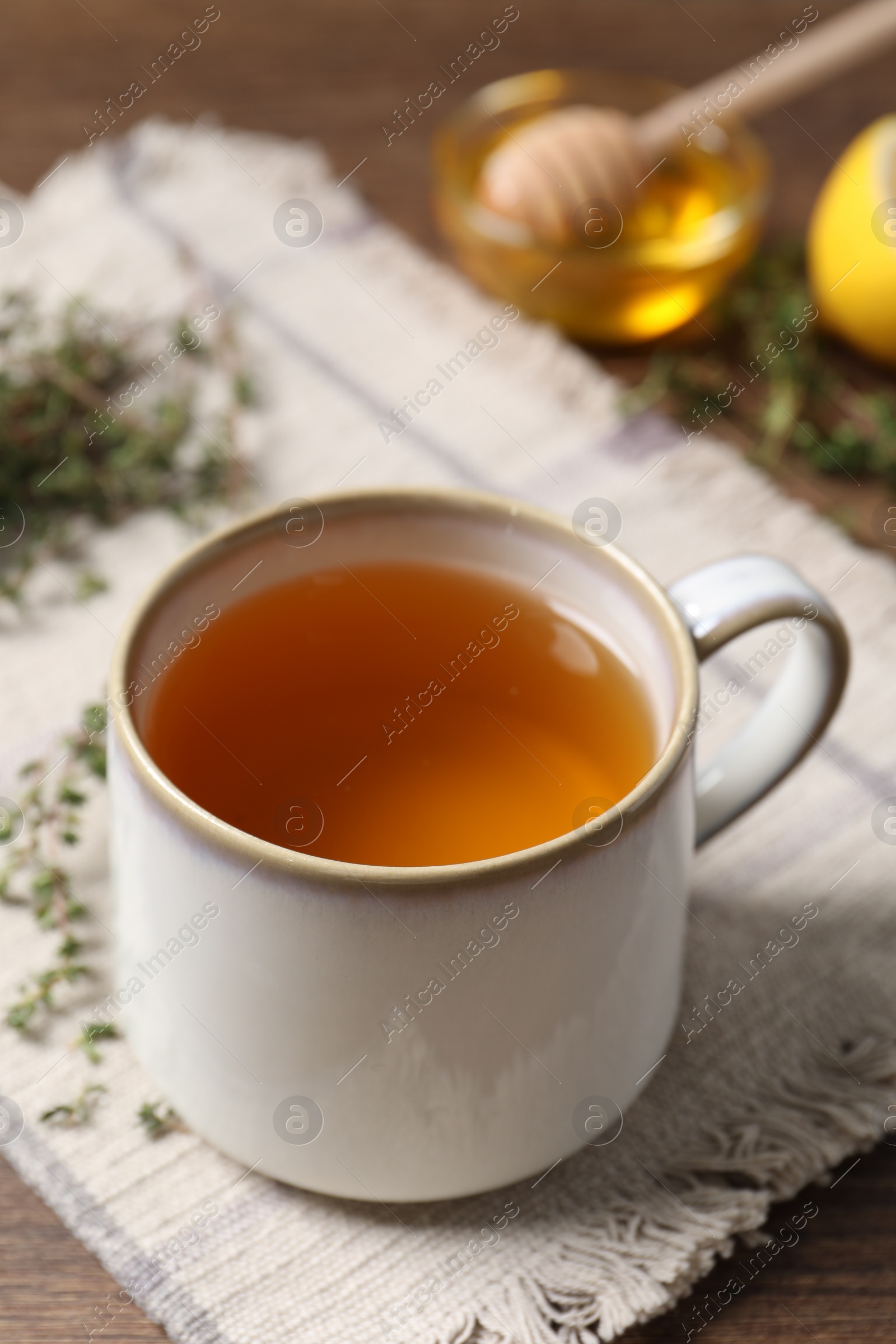 Photo of Aromatic herbal tea with thyme on wooden table