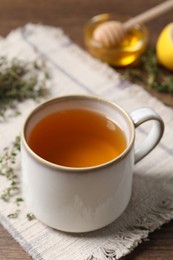 Aromatic herbal tea with thyme on wooden table