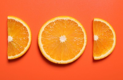 Slices of juicy orange on terracotta background, flat lay