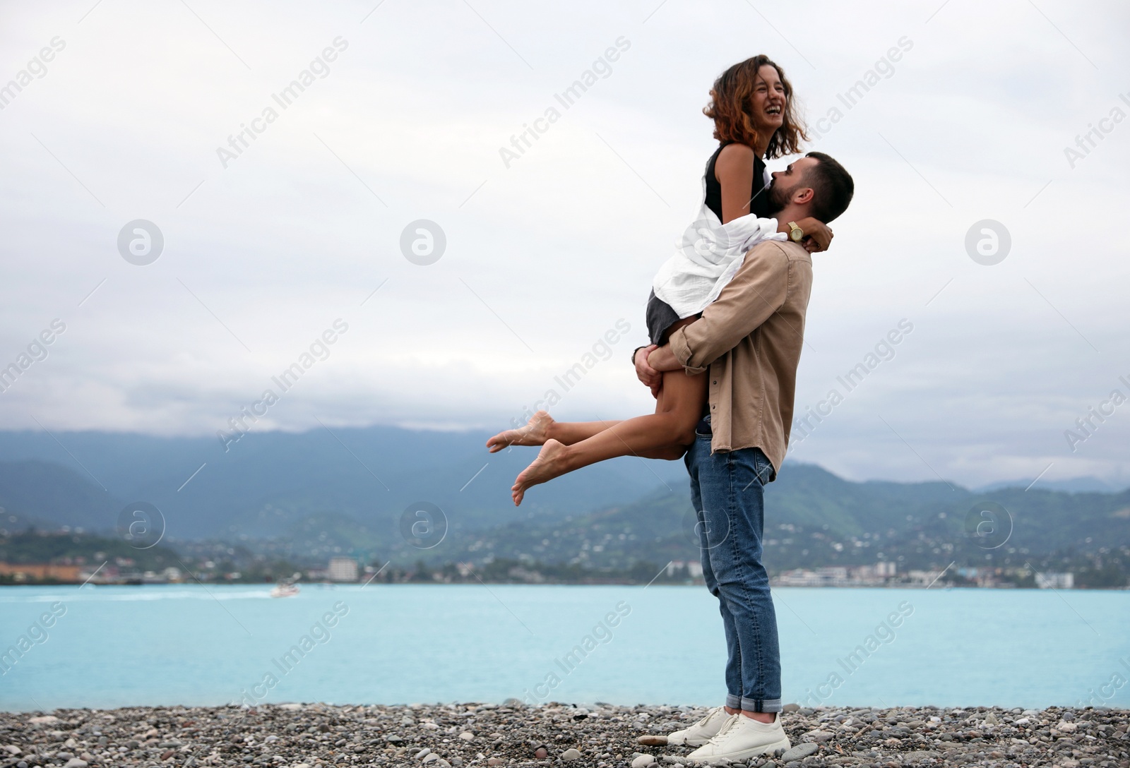 Photo of Beautiful young couple enjoying time together on beach, space for text