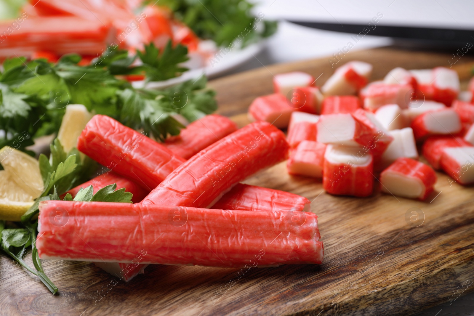 Photo of Delicious crab sticks on wooden board, closeup