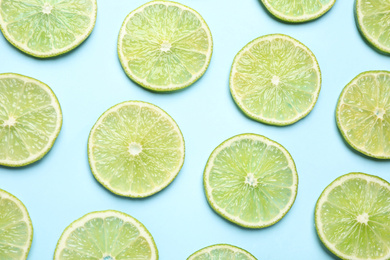 Photo of Fresh juicy lime slices on light blue background, flat lay