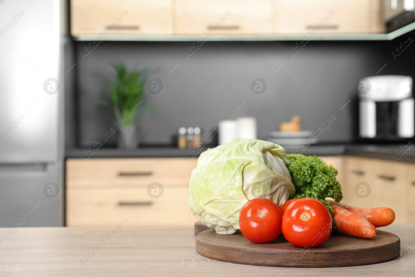 Photo of Fresh vegetables on wooden table in kitchen. Space for text