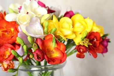 Photo of Beautiful spring freesia flowers in vase, closeup