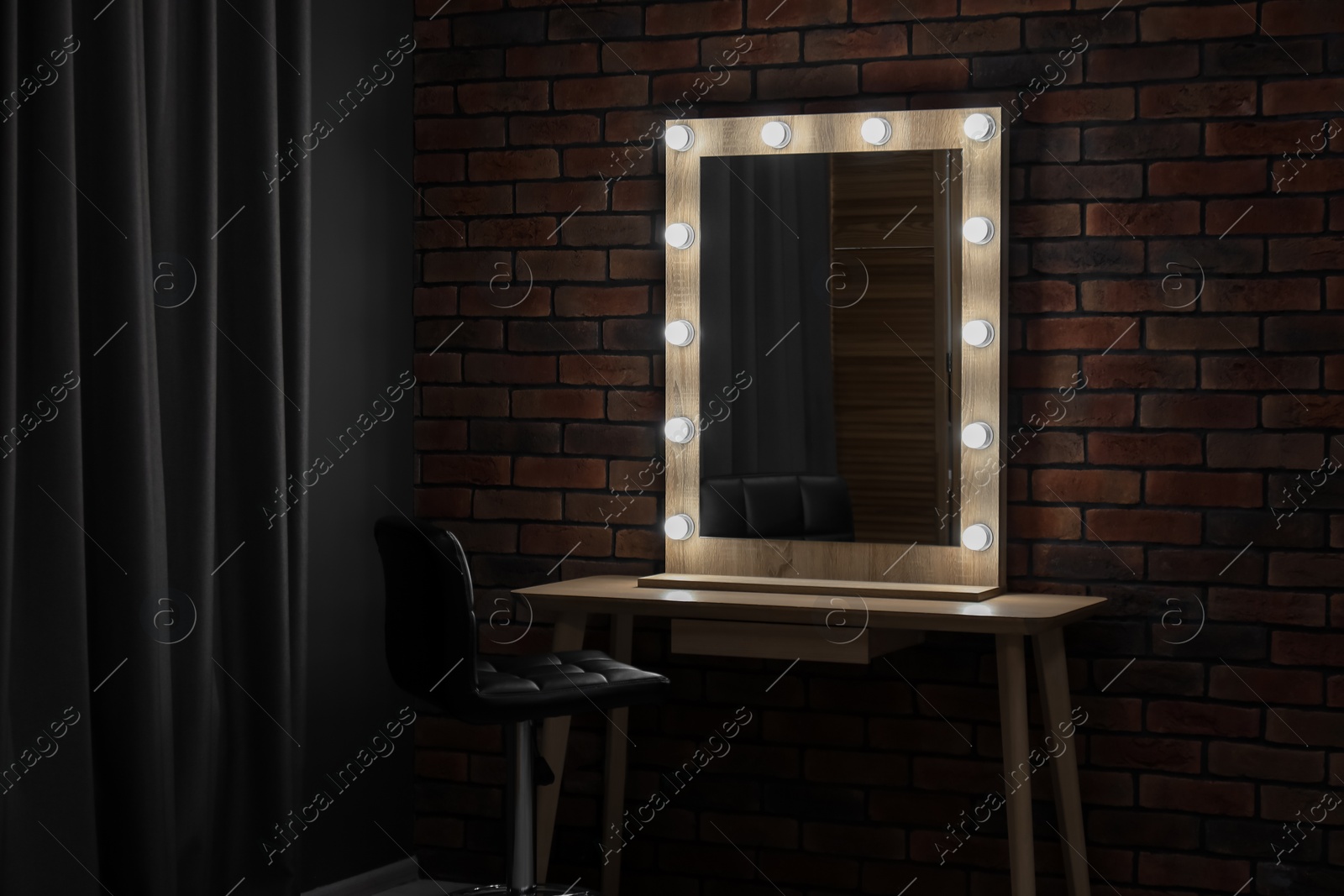 Photo of Mirror with light bulbs, table, chair and curtain in makeup room