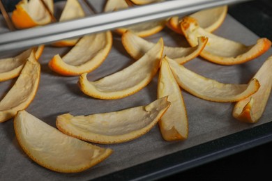 Photo of Baking tray with orange peels in oven, closeup