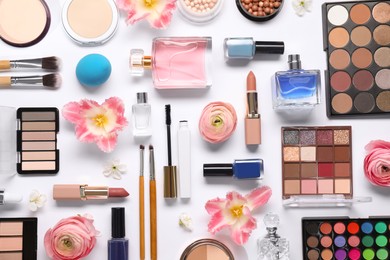 Flat lay composition with different makeup products and beautiful spring flowers on white background