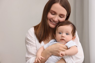 Happy mother with her little baby indoors