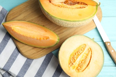 Photo of Tasty fresh melons on light blue wooden table, flat lay