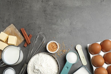 Flat lay composition with fresh ingredients for delicious homemade cake on grey table. Space for text