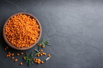 Photo of Fresh ripe sea buckthorn on black table, flat lay. Space for text