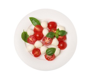 Photo of Plate of delicious Caprese salad with tomatoes, mozzarella and basil isolated on white, top view