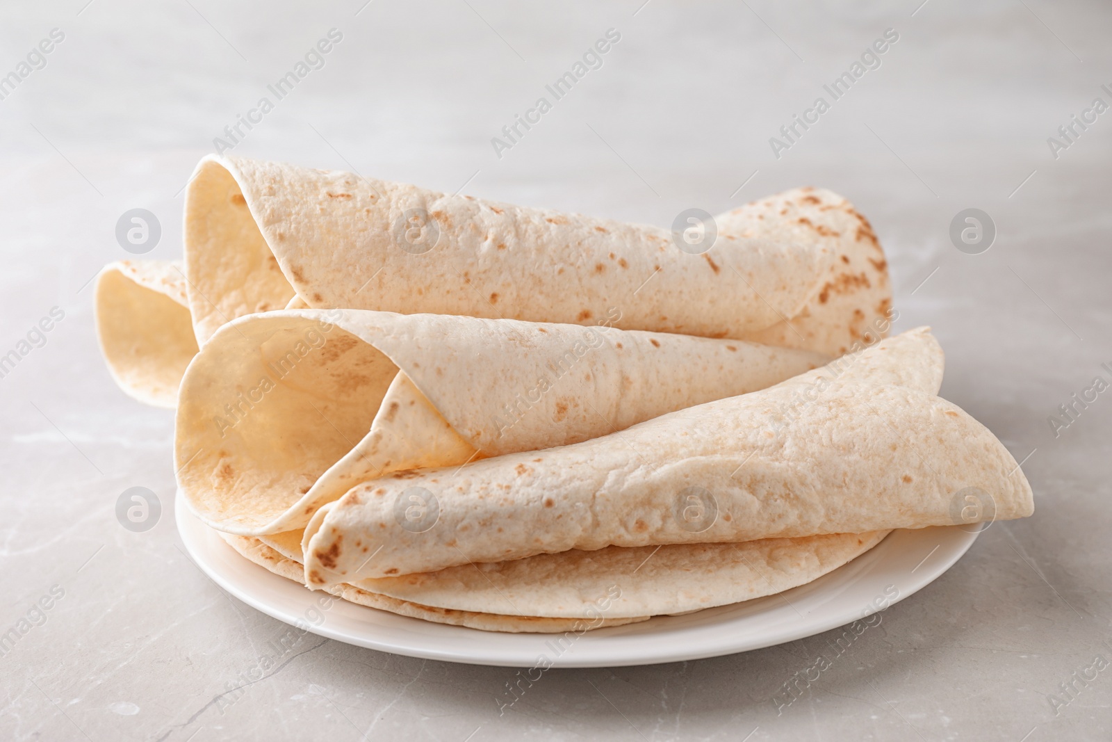 Photo of Plate with corn tortillas on table. Unleavened bread