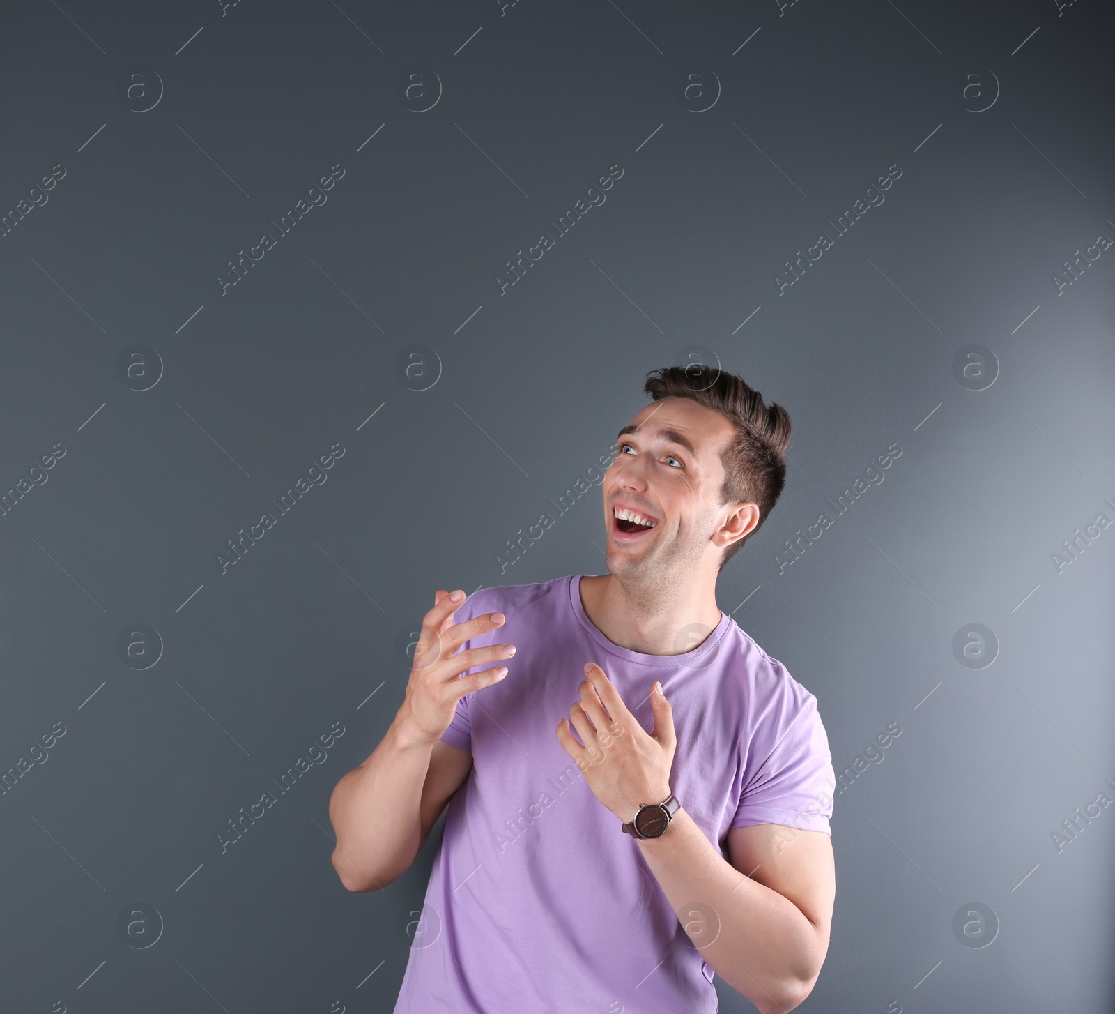 Photo of Handsome emotional young man on color background