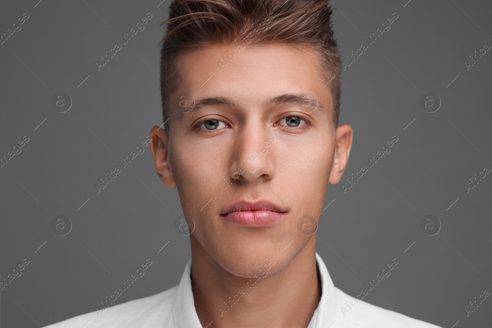 Photo of Portrait of handsome young man on grey background