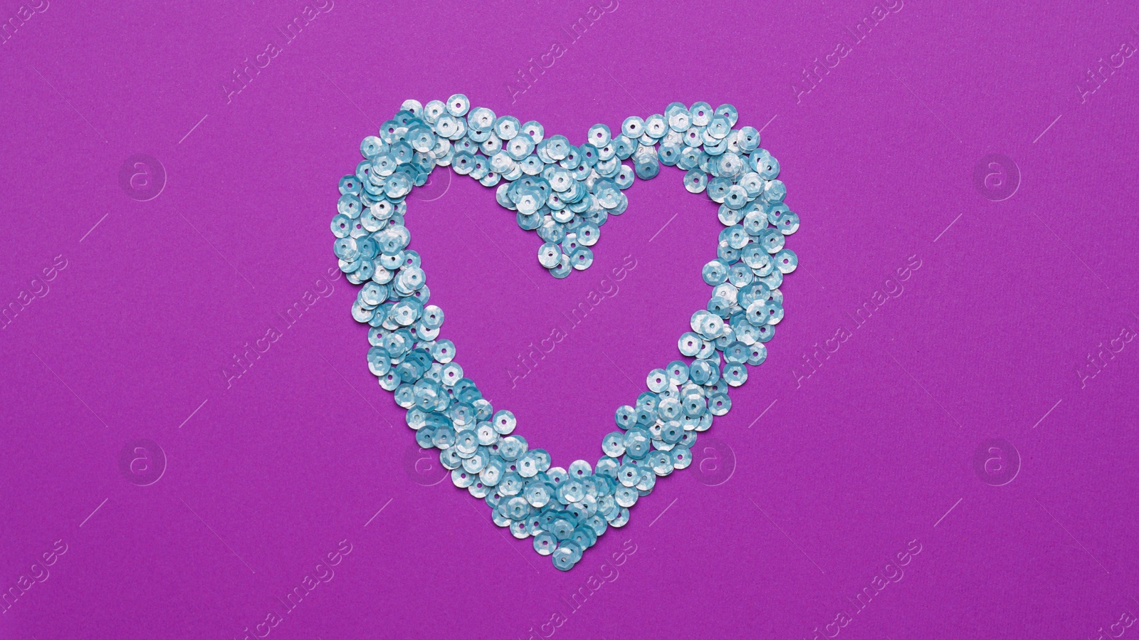 Photo of Heart made of silver sequins on purple background, top view