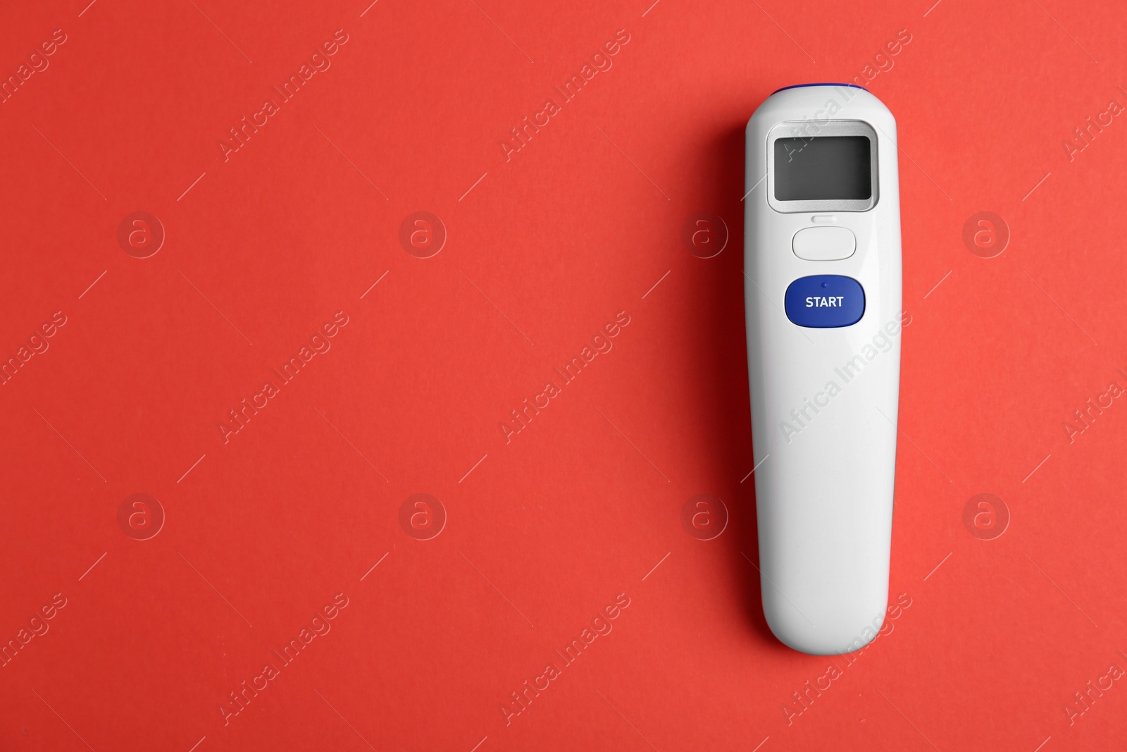 Photo of Modern non-contact infrared thermometer on red background, top view. Space for text