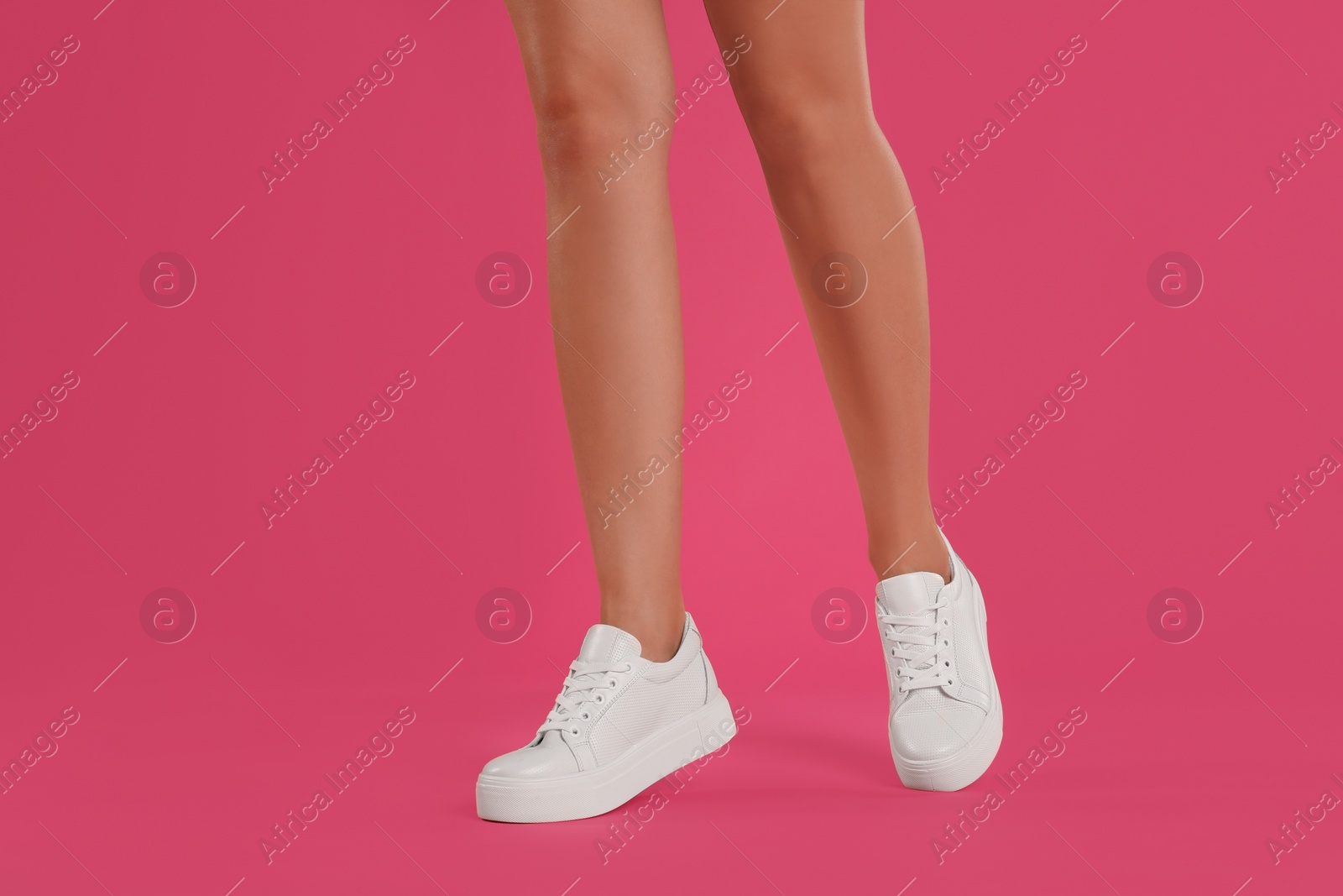 Photo of Woman wearing shoes on pink background, closeup