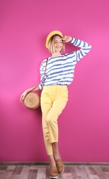 Photo of Beautiful young woman posing near color wall. Summer fashion