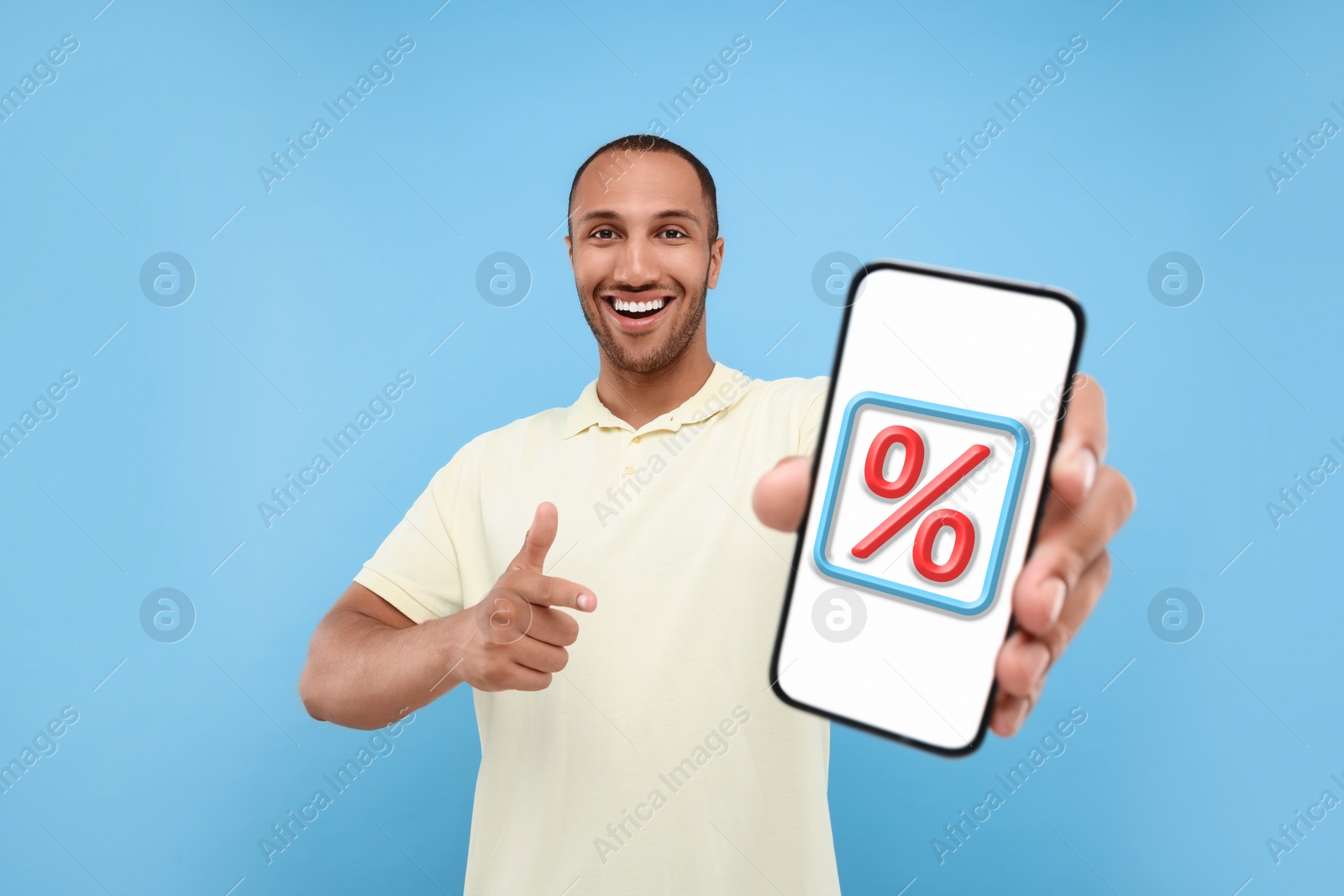 Image of Discount, offer, sale. Man pointing at mobile phone with percent sign on screen, light blue background