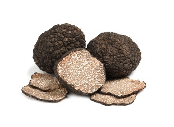 Cut and whole black truffles isolated on white