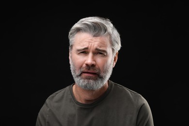 Photo of Personality concept. Portrait of emotional man on black background