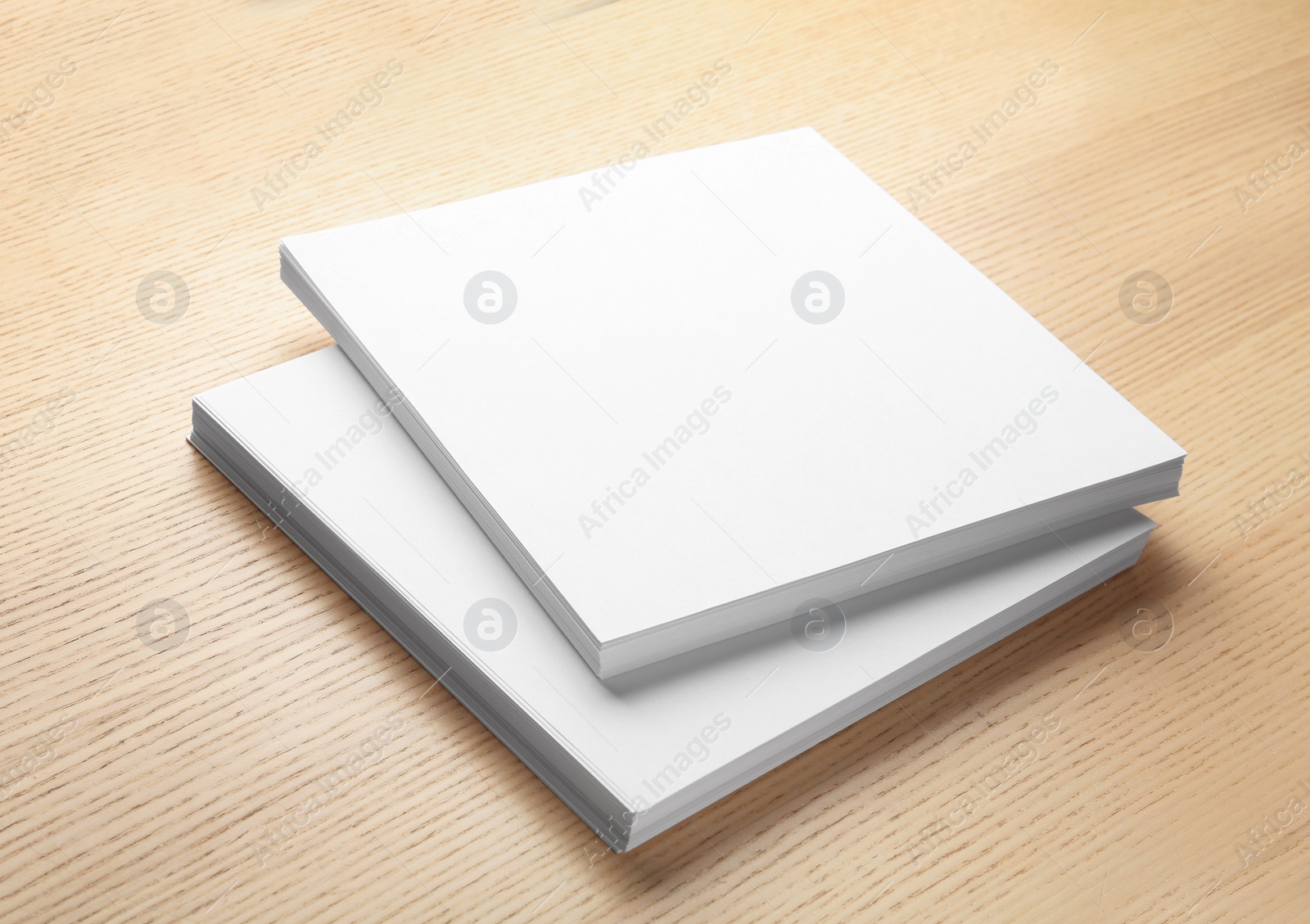 Photo of Stack of blank paper sheets for brochure on wooden background. Mock up