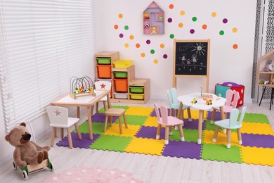 Stylish kindergarten interior with toys and modern furniture