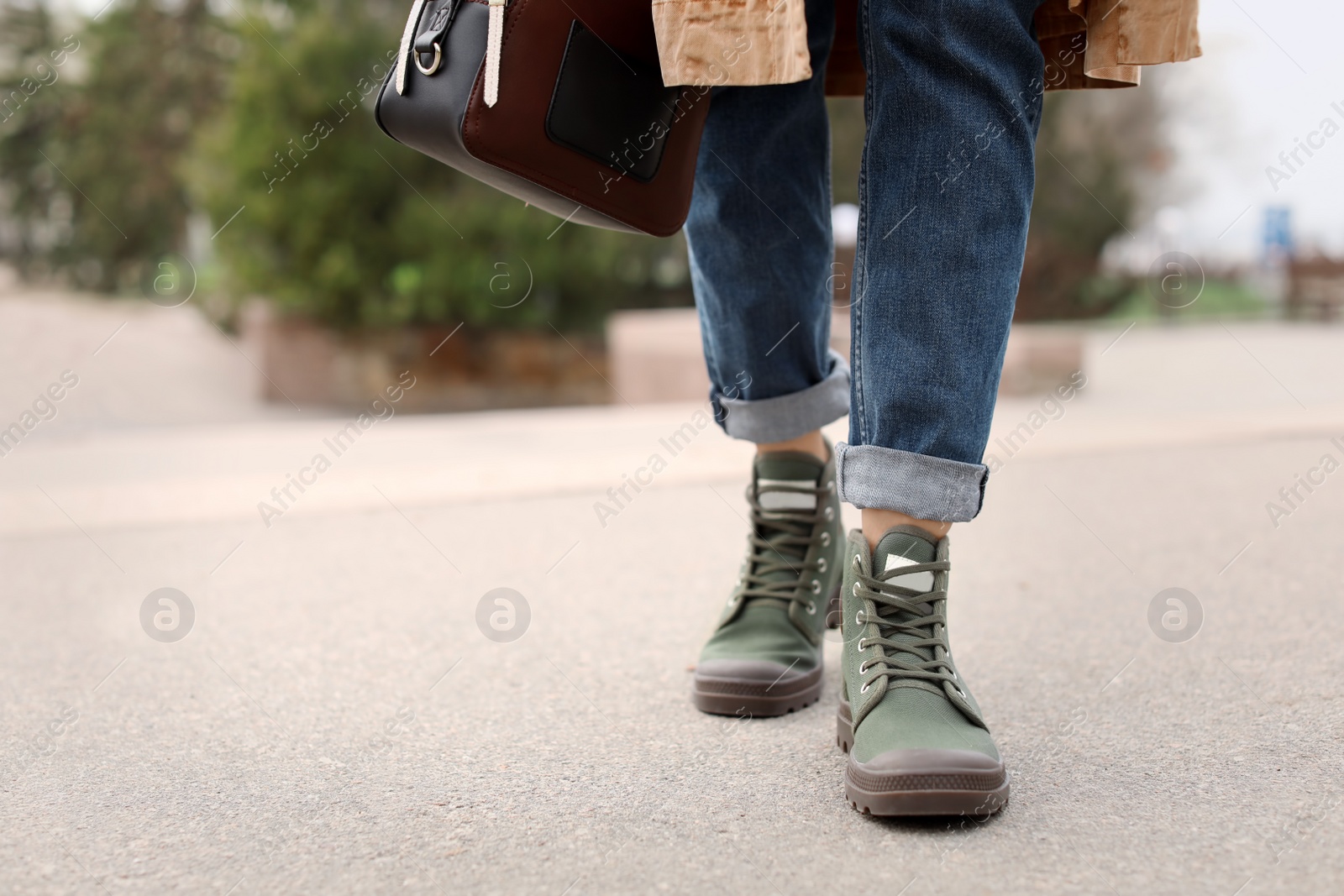 Photo of Young woman in comfortable casual shoes walking on street