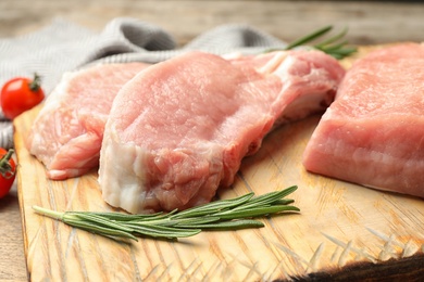 Photo of Board with fresh raw cut meat on table, closeup