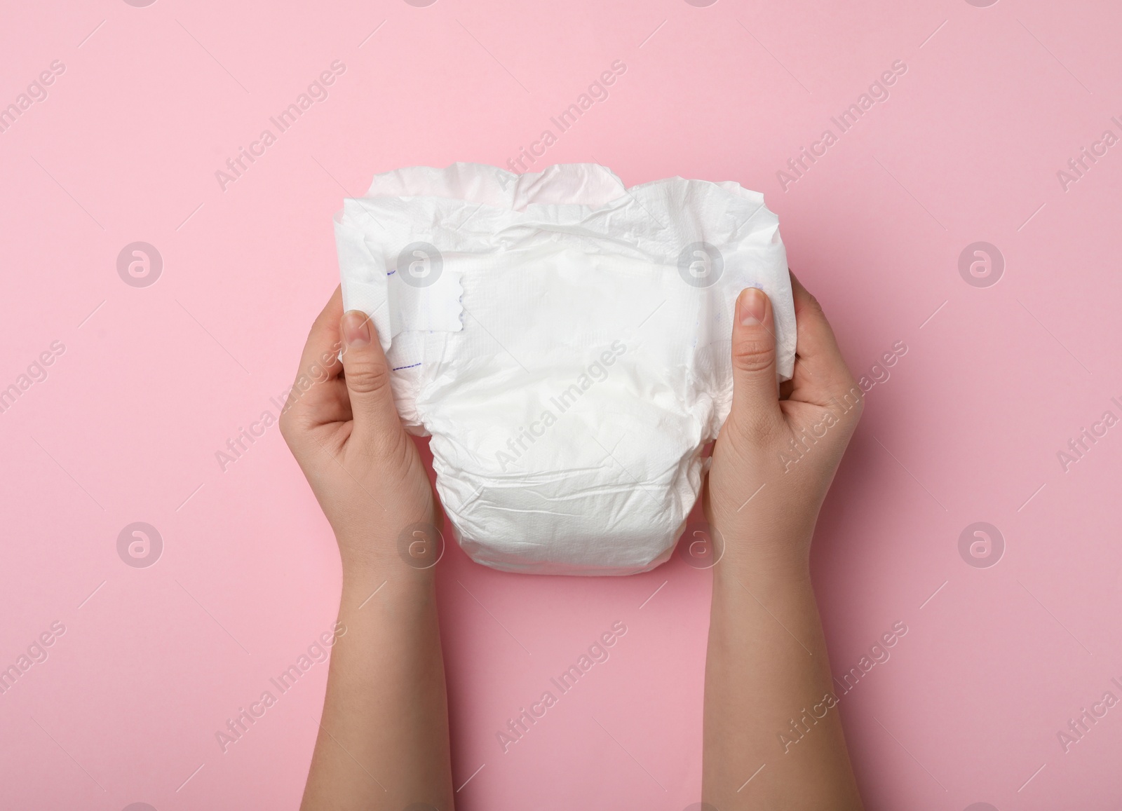 Photo of Woman with diaper on pink background, closeup