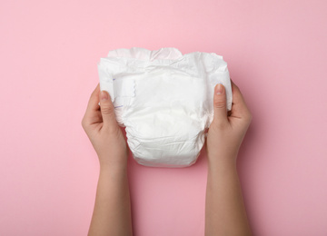 Photo of Woman with diaper on pink background, closeup