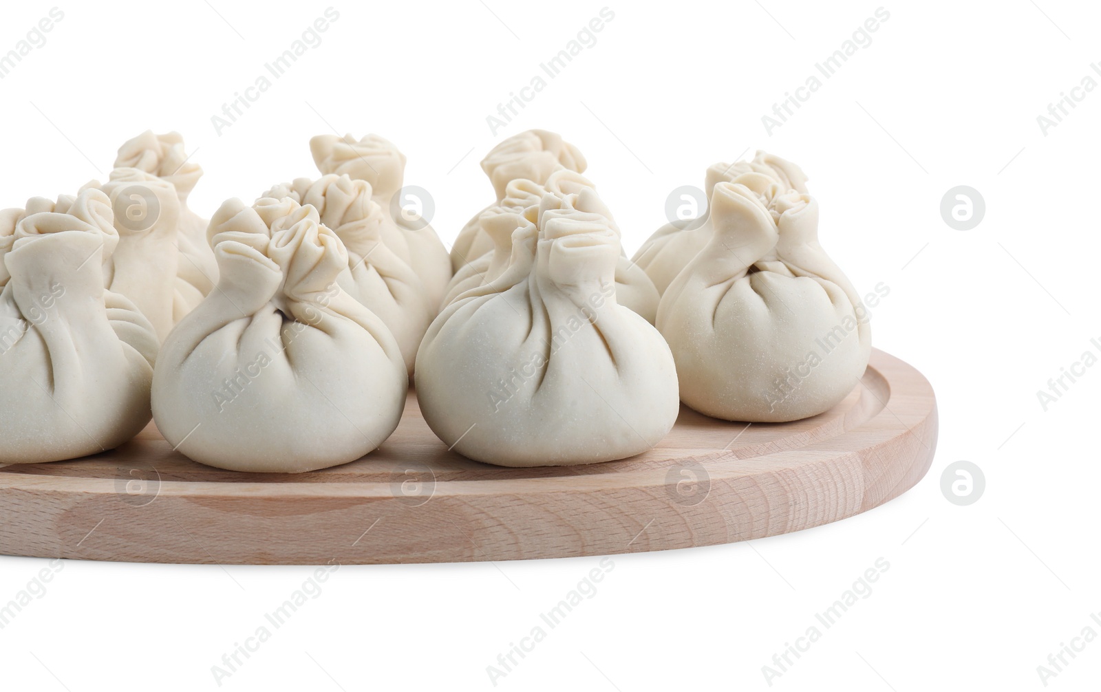 Photo of Wooden board with uncooked khinkali (dumplings) isolated on white. Georgian cuisine