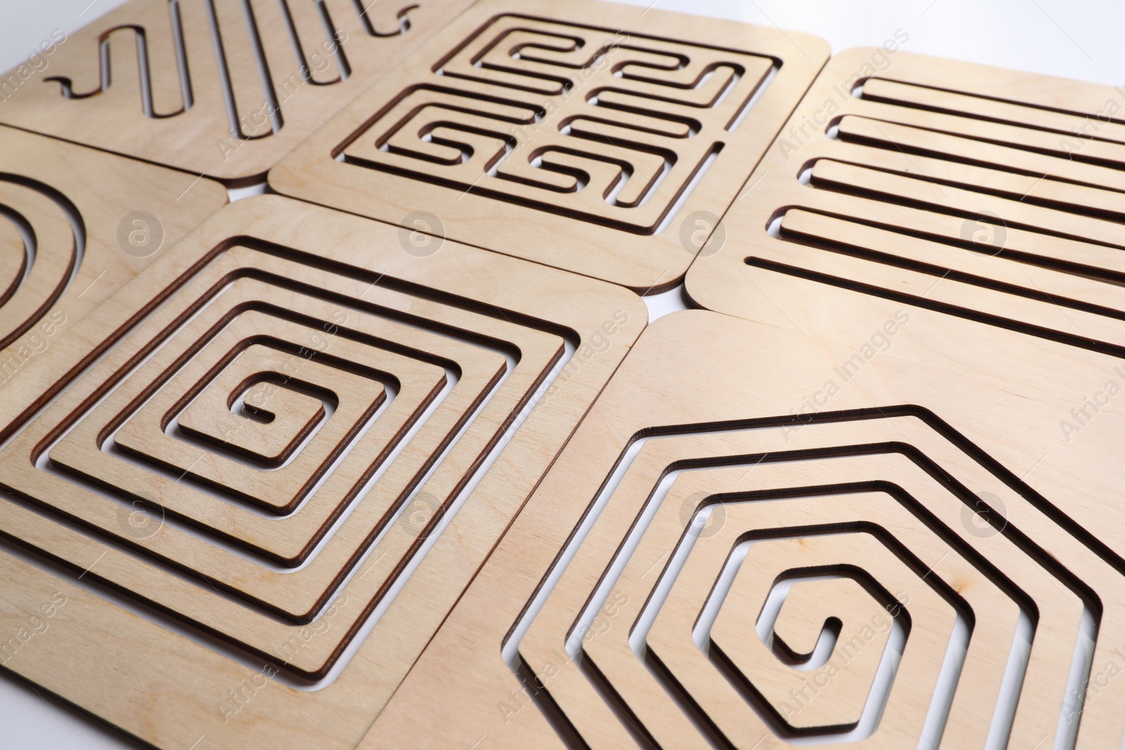 Photo of Wooden finger labyrinths on white background, closeup. Montessori toy