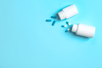 Photo of Flat lay composition with bottles, pills and space for text on color background