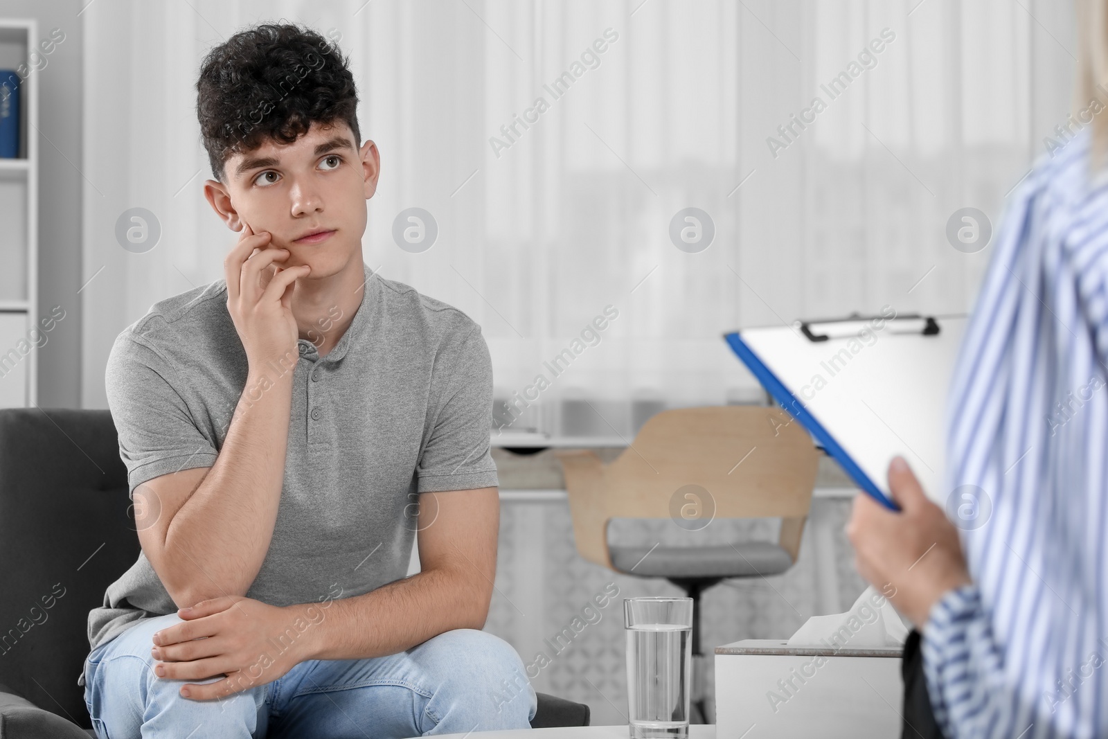 Photo of Psychologist working with teenage boy in office. Teenager problems